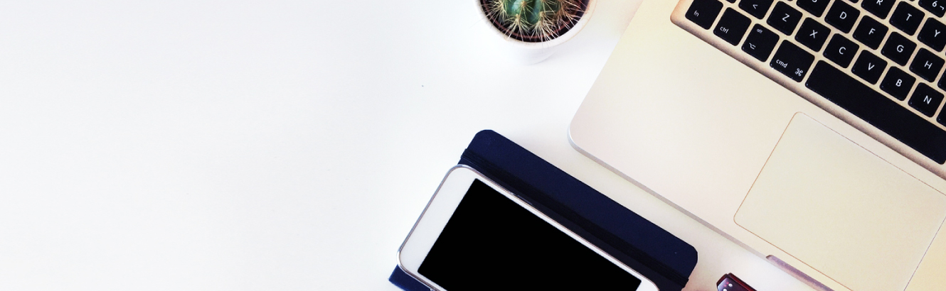 Top down view of desk with mobile phone and laptop